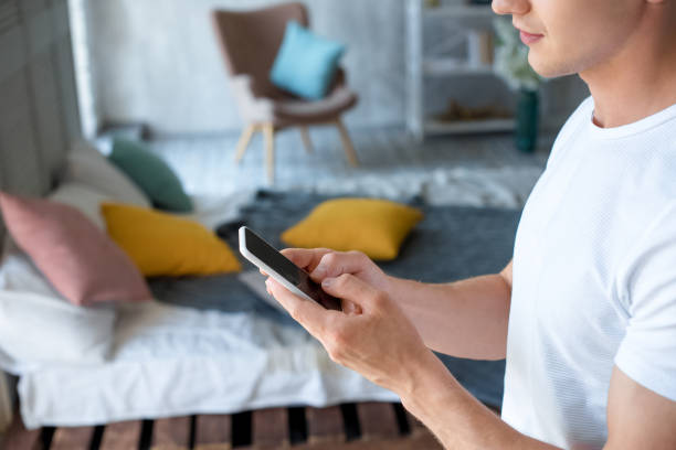 istock side view of young man using smartphone at home 1002041876
