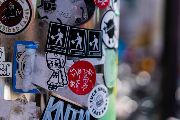 A light post covered in graffiti and stickers in Tustenkaku, Osaka. Kind of a rough looking area.
