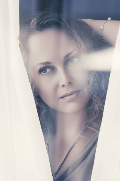 istock Sad beautiful woman looking out window 1002042598