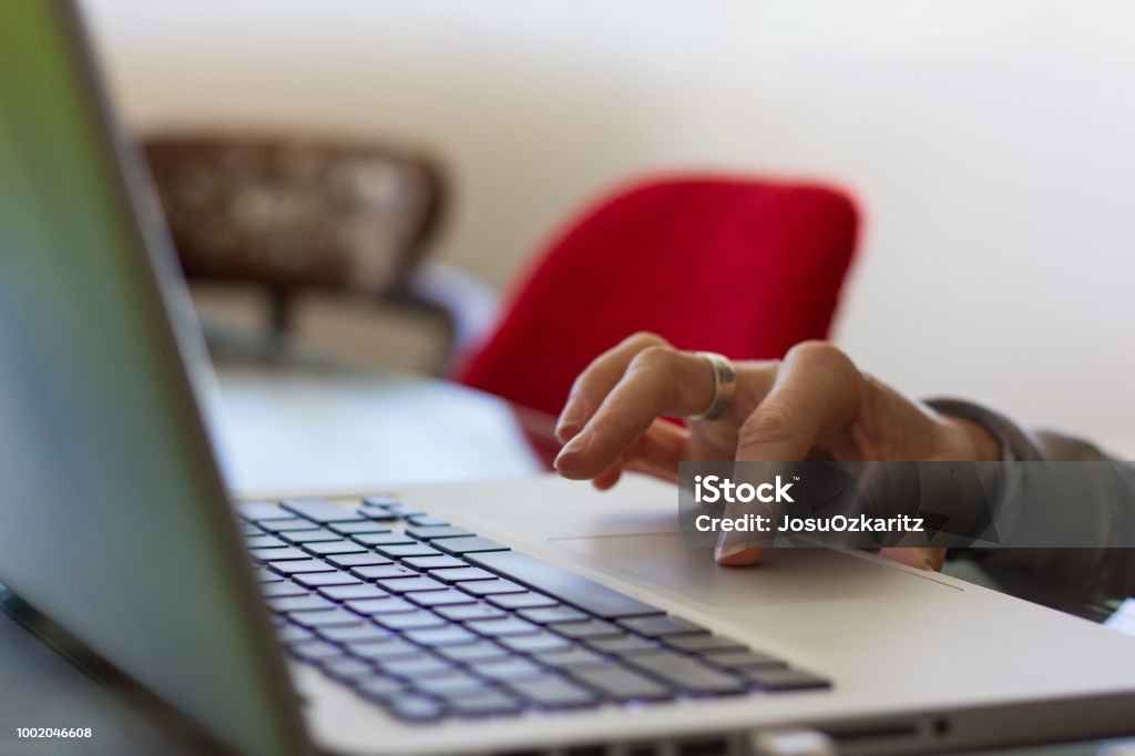 Hand of woman on touch pad of silver color laptop working from home Online shopping, web designer, internet search, identity security, freelance concepts Adult Stock Photo