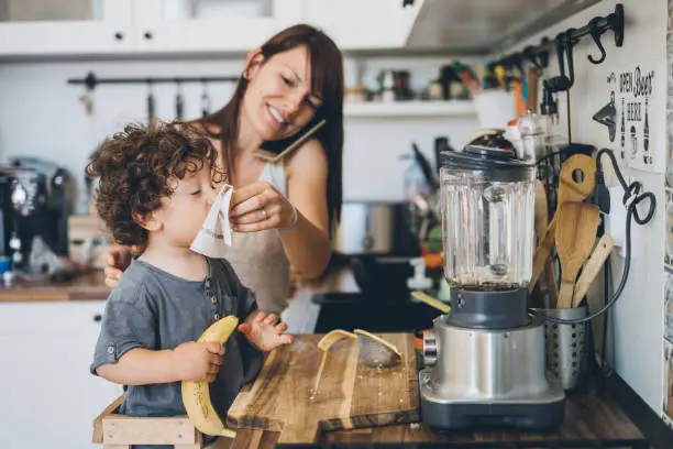 Photo of Mother helping son to blow his nose