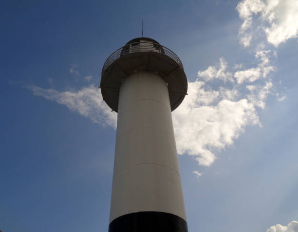 istock A lighthouse in port, blue summer sky and cloud 1002053826