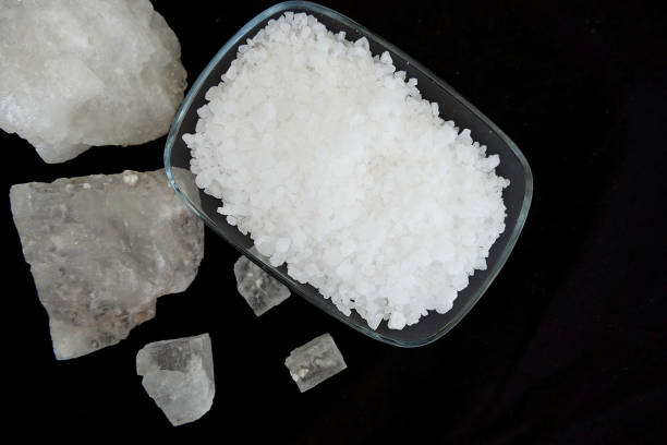 istock natural rock salt fragments on the black background, 1002054418