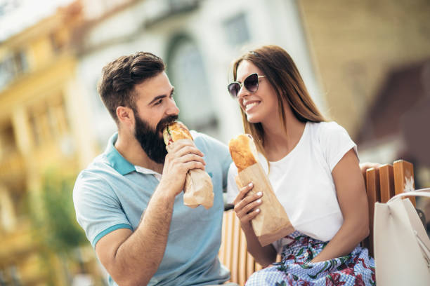 istock Young couple is eating sandwiches and having a great time 1002054996
