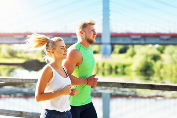istock Young couple jogging in park 1002061864