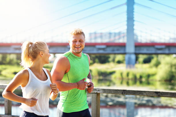 istock Young couple jogging in park 1002061980