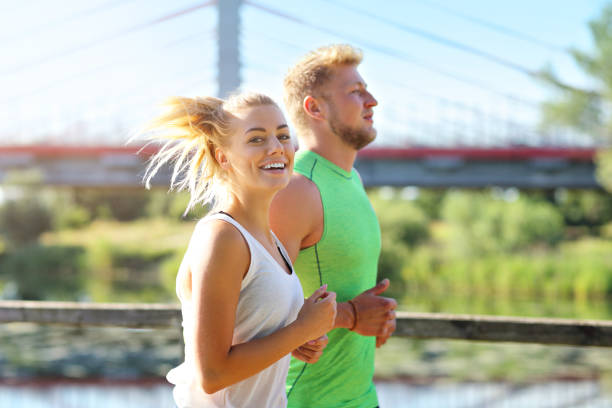 istock Young couple jogging in park 1002062050