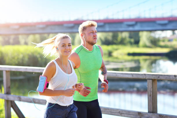 istock Young couple jogging in park 1002062142