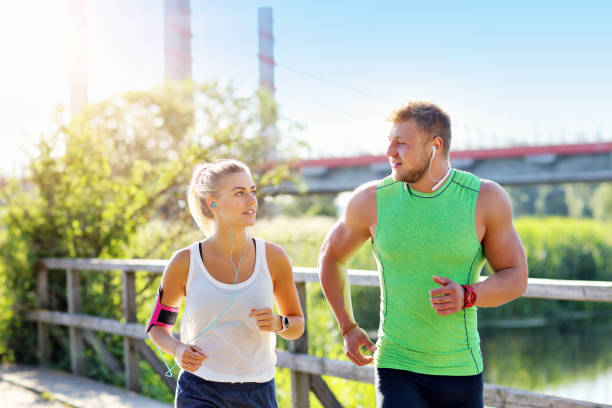 istock Young couple jogging in park 1002062228
