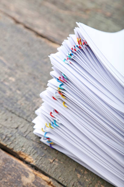 istock Stack of papers with paperclips on wooden table 1002068384