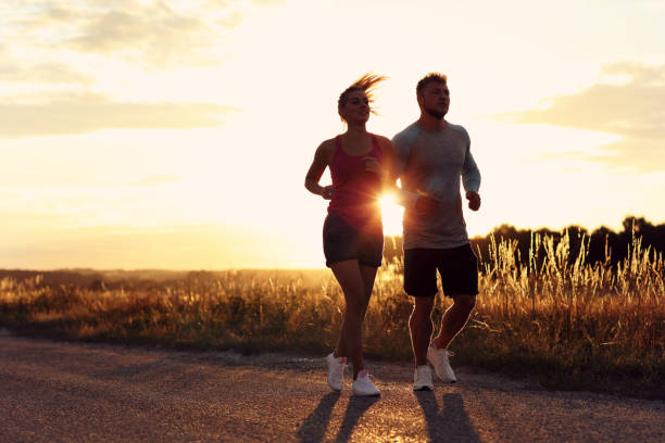istock Young couple jogging in the suberbs after sunset 1002072050