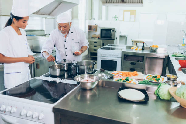 istock Asian chef and assistant preparing food in restaurant 1002072560