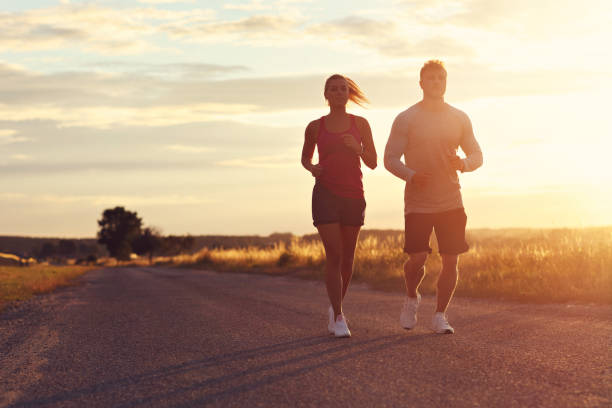istock Young couple jogging in the suberbs after sunset 1002072838