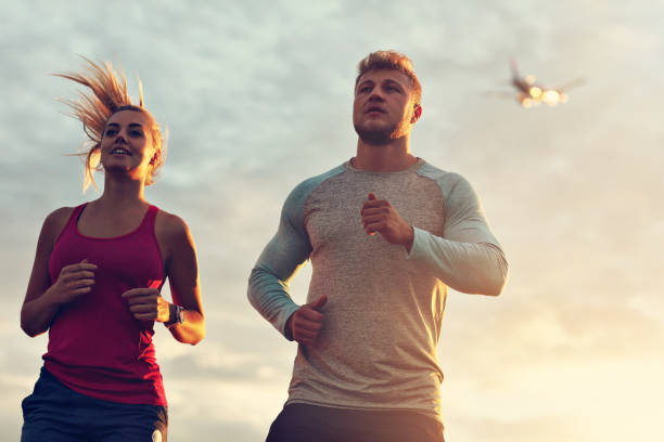 istock Young couple jogging in the suberbs after sunset 1002072944