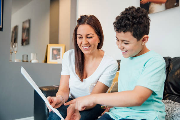 Dad Will Love What we Made! Little boy and his mother are looking at the Father's Day card they have made together at home. report card stock pictures, royalty-free photos & images