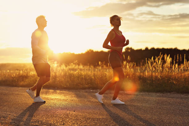 istock Young couple jogging in the suberbs after sunset 1002075070