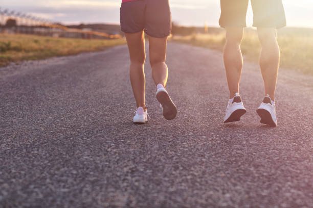 istock Young couple jogging in the suberbs after sunset 1002075300
