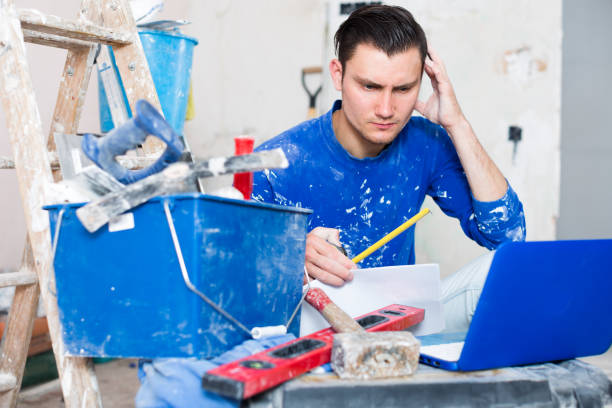 istock Male contractor working with papers and laptop 1002082506