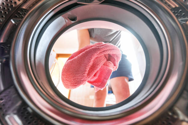 Young man doing laundry view from the inside of washing machine Young man doing laundry view from the inside of washing machine tumble dryer stock pictures, royalty-free photos & images