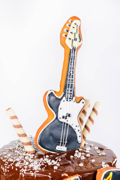 istock Decorative guitar on appetizing sweet  dark glaze cake on light 1002091126