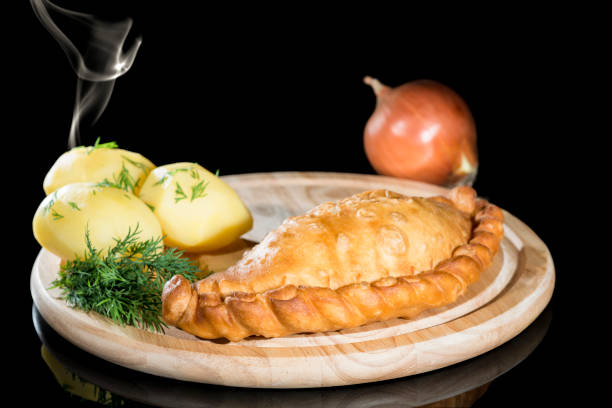 istock pie with potatoes on a wooden board with steam on a dark backgro 1002091328