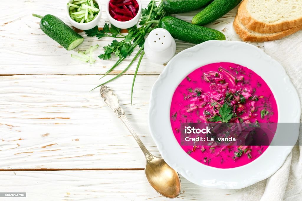 Cold fresh traditional vegetable summer soup made of beetroot (beet), cucumber, dill, parsley, green onion, eggs and sour cream (kefir). Holodnik. borsch Borscht Stock Photo