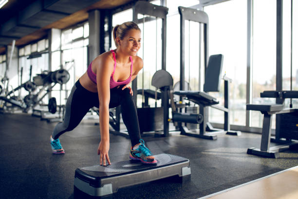 istock Woman doing lunges on step aerobics equipment at gym 1002095050