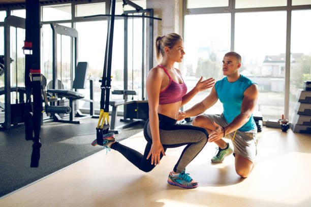 istock Woman doing leg exercises with suspension straps at gym 1002095190