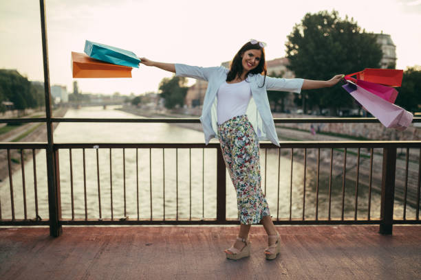istock Happy young woman having fun while shopping 1002098308