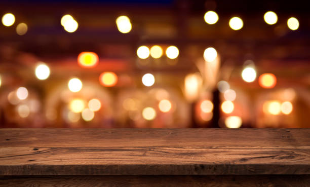 istock Wooden table for product display on abstract restaurant lights background 1002098742