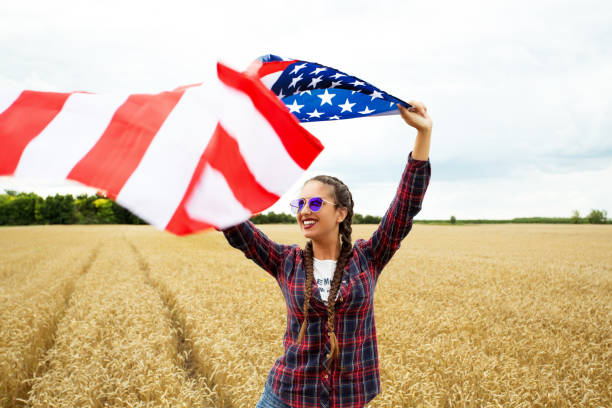 istock Young beautiful woman holding USA flag 1002107012