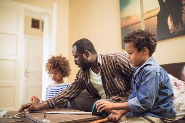 istock Kids assisting their father repairing the shelf 1002107104