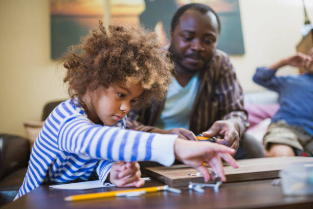 istock Kids assisting their father repairing the shelf 1002107182
