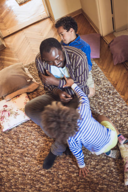 istock Kids having fun at home, playing with their father 1002107342