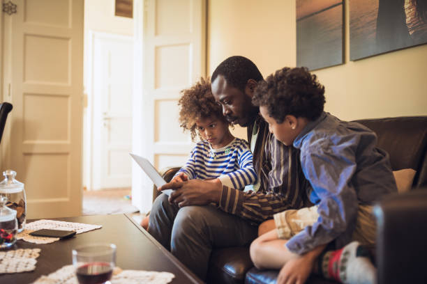 istock Kids having fun at home, playing with their father, using laptop 1002107396
