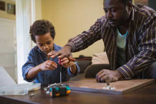 istock Kids assisting their father repairing the shelf 1002107524