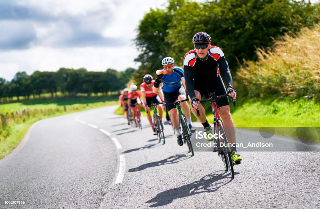 Cyclists racing on country roads. Cyclists racing on country roads on a sunny day in the UK.Cyclists racing on country roads on a sunny day in the UK. Cycling Stock Photo