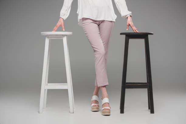 istock cropped image of female model standing between chairs on grey background 1002109282