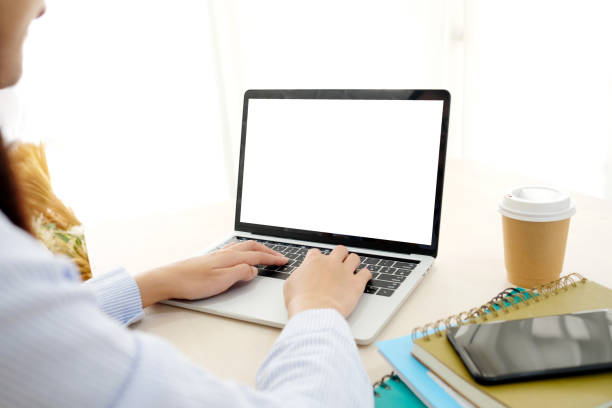 istock Woman hands typing laptop computer with blank screen for mock up template background, top view, business technology and lifestyle background concept 1002111764