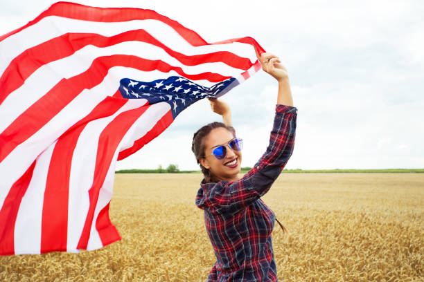 istock Young beautiful woman holding USA flag 1002111954