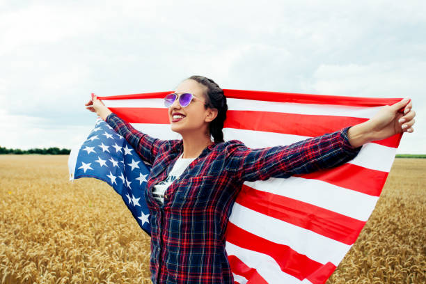 istock Young beautiful woman holding USA flag 1002113034