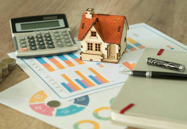 istock Financial paper and work station and house model with tablet on working table, business concept. 1002113526