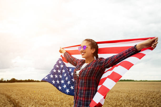 istock Young beautiful woman holding USA flag 1002114014