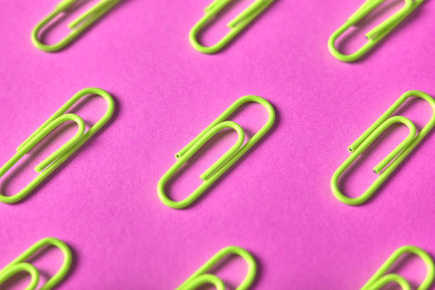 istock Yellow paper clips isolated on pink background, close up, copy space. Top view, flat lay. Back to school, college, education concept 1002118872