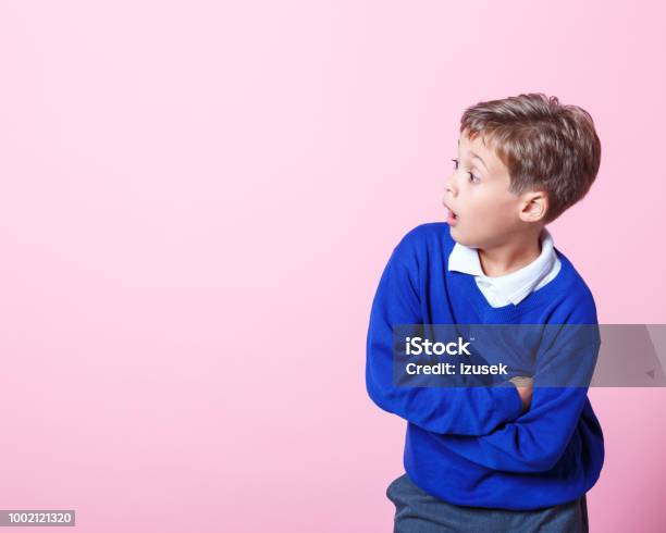 Portrait Of Surprised Schoolboy Looking Away With Mouth Open Stock Photo - Download Image Now