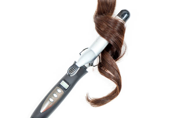 istock Curly dark hair with a curling iron isolated on white background 1002121644