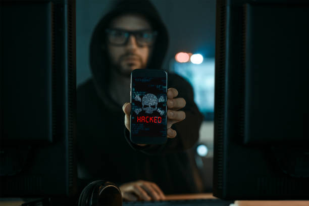 Hacker Hacker working showing smart phone with inscription Hacked. Cyber crime concept. anonymous phone stock pictures, royalty-free photos & images