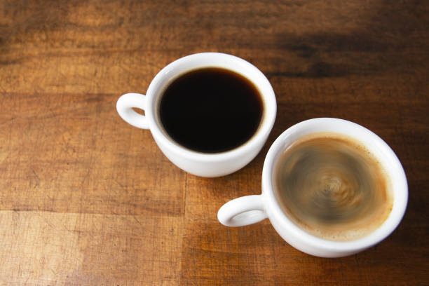 istock Coffee cups on wooden table background 1002128212