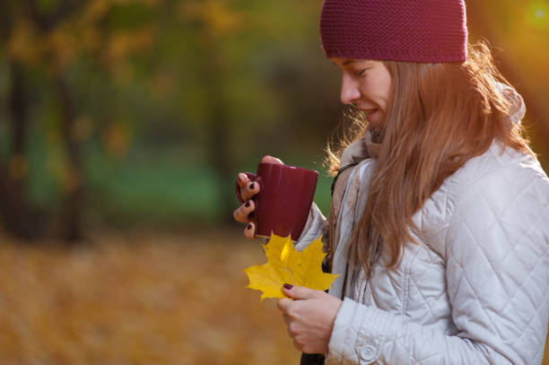 istock Beautiful autumn woman drinking coffee in park 1002131188