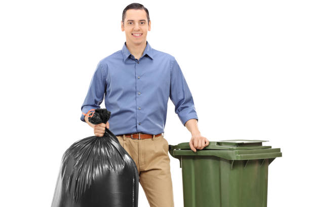 istock Young man with a trash bag and a garbage can 1002132492